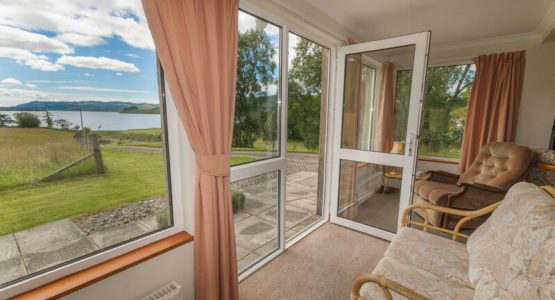 Sunroom in Barr-beithe-lower open door to garden and views of a loch