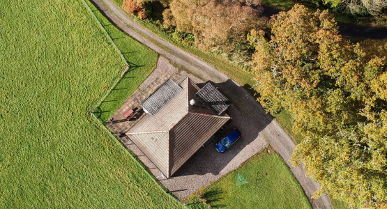 Barr-beithe Lower from above An aerial photo taken of a cottage surrounded by trees and a field